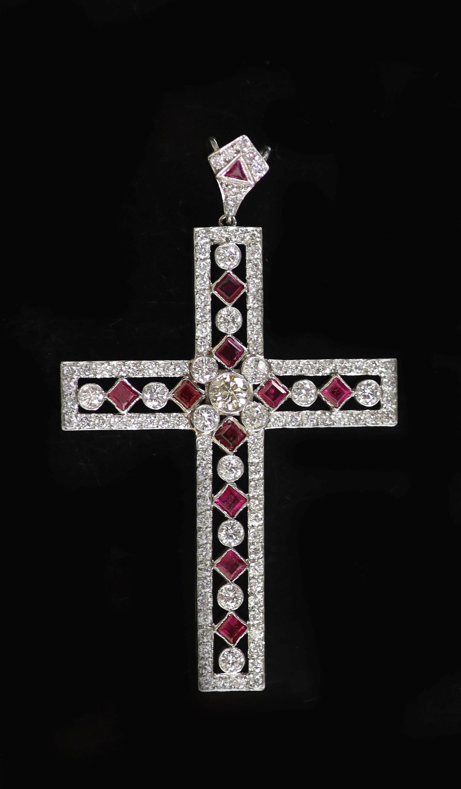 A modern pierced white gold, ruby and diamond cross pendant